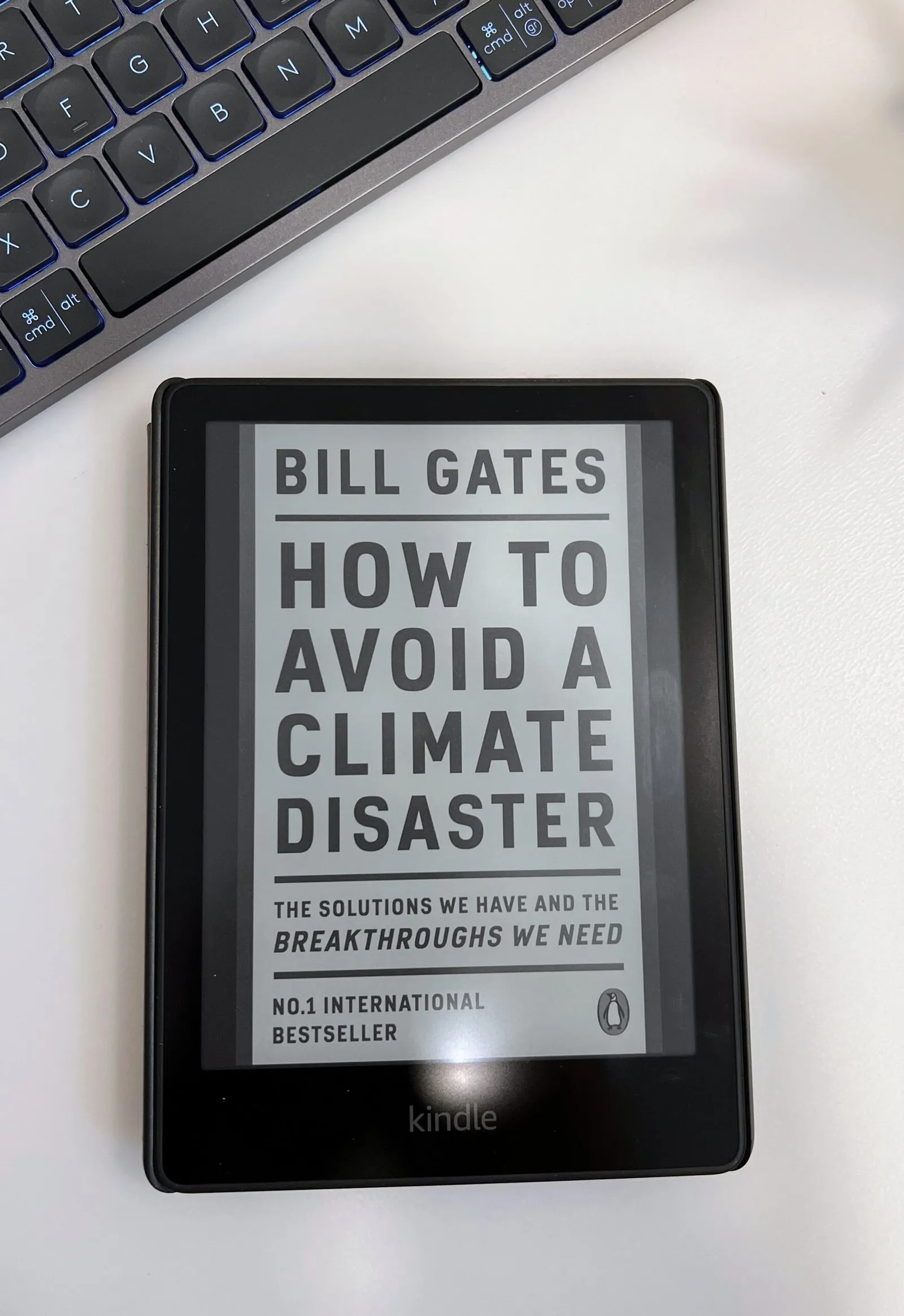 Bill Gates’ “How to Avoid a Climate Disaster” open on an e-reader next to a keyboard.